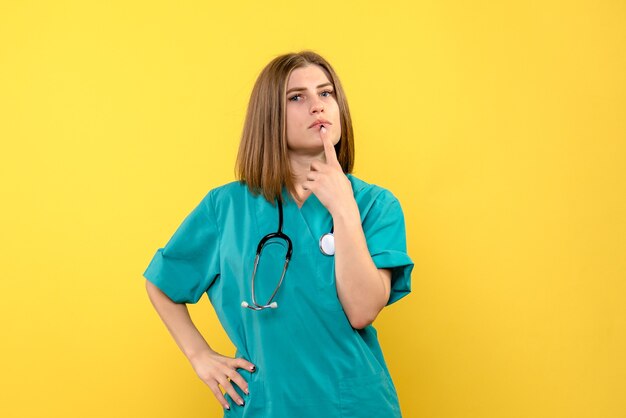 Medico femminile di vista frontale che posa appena sullo spazio giallo