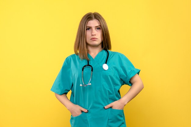 Medico femminile di vista frontale che posa appena sullo spazio giallo