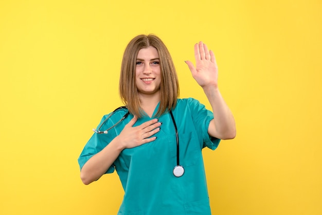 Medico femminile di vista frontale che posa sullo spazio giallo