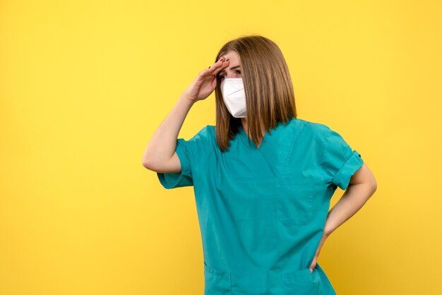 Medico femminile di vista frontale che posa sullo spazio giallo