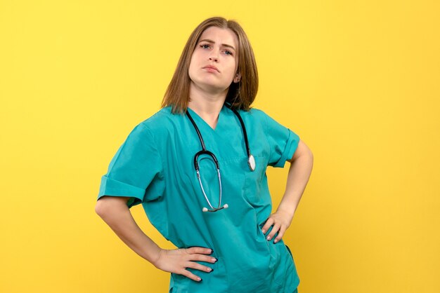 Medico femminile di vista frontale che posa sullo spazio giallo