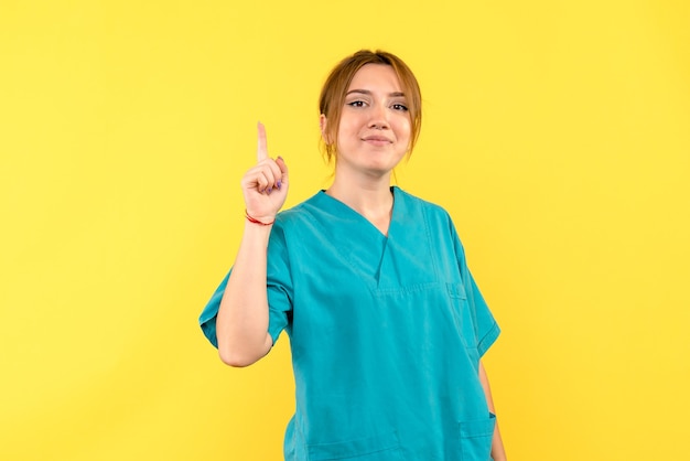 Medico femminile di vista frontale che sorride sullo spazio giallo