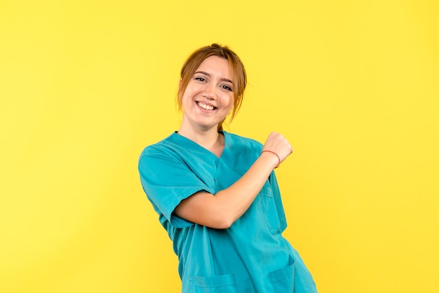 Medico femminile di vista frontale che sorride sullo spazio giallo