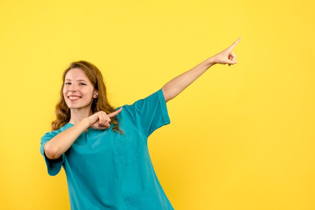 Medico femminile di vista frontale che sorride sullo spazio giallo