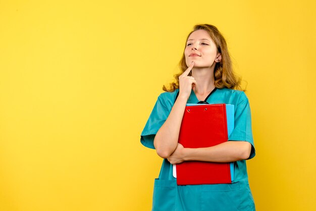 Medico femminile di vista frontale che sorride sullo spazio giallo