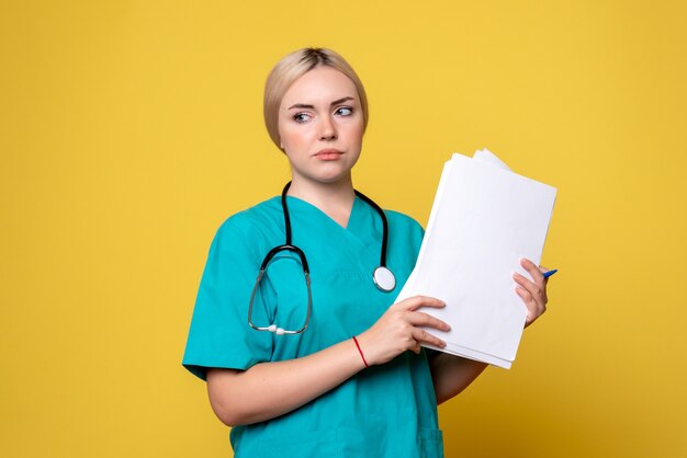 Medico femminile di vista frontale che tiene analisi e documenti, ospedale infermieristico covid del virus della medicina di salute del coronavirus