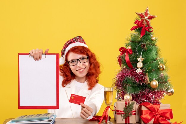 Medico femminile di vista frontale che tiene la carta di credito e la nota