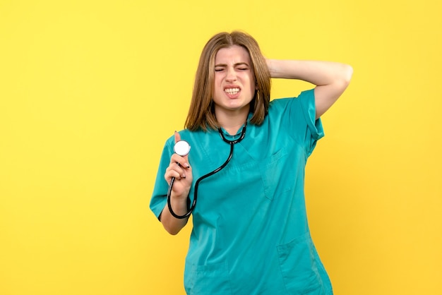 Medico femminile di vista frontale che tiene tonometro sullo spazio giallo