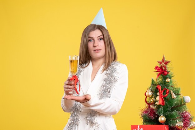 Medico femminile di vista frontale che tiene vetro di champagne e che celebra