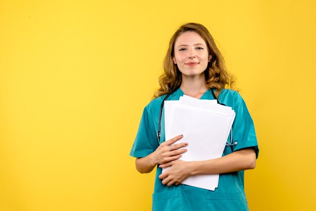 Medico femminile di vista frontale con file su spazio giallo