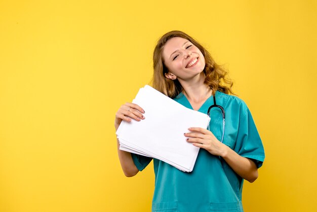 Medico femminile di vista frontale con file su spazio giallo