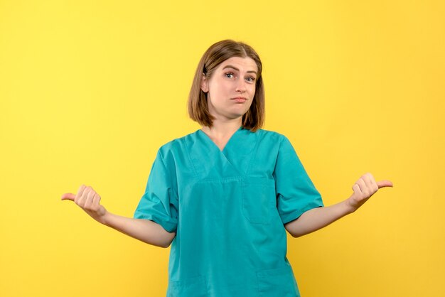 Medico femminile di vista frontale con l'espressione annoiata sullo spazio giallo