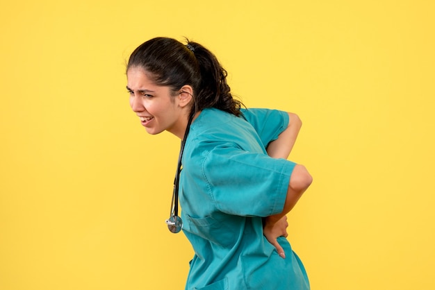 Medico femminile di vista frontale con lo stetoscopio che la tiene in piedi indietro