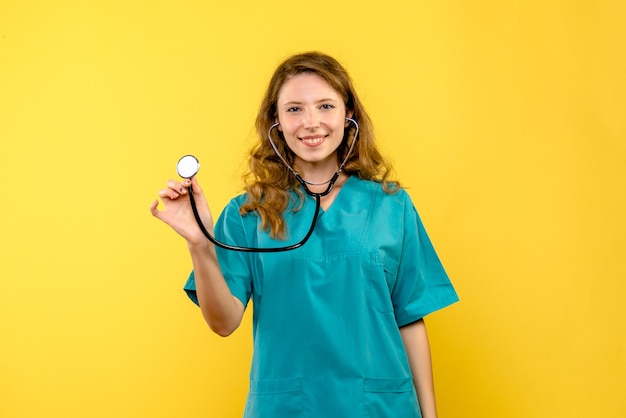 Medico femminile di vista frontale con lo stetoscopio sullo spazio giallo