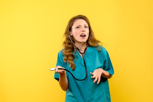 Medico femminile di vista frontale con lo stetoscopio sullo spazio giallo
