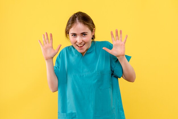 Medico femminile di vista frontale eccitato sull'emozione dell'ospedale del medico di salute del fondo giallo