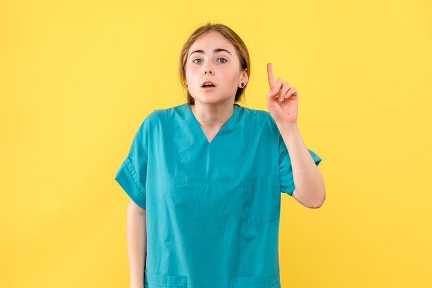 Medico femminile di vista frontale ha un'idea sulla salute del medico di emozione dell'ospedale del fondo giallo
