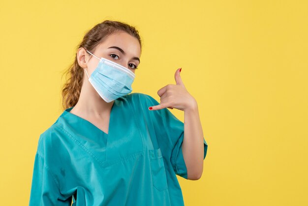 Medico femminile di vista frontale in camicia e maschera medica, salute uniforme del coronavirus di pandemia di virus covid-19