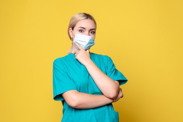 Medico femminile di vista frontale in camicia e maschera mediche, medico pandemico di salute dell'infermiere covid-19