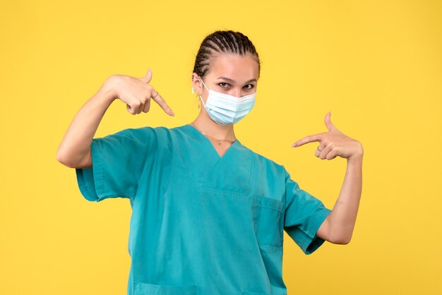 Medico femminile di vista frontale in camicia e maschera mediche, ospedale covid-19 pandemico del virus dell'infermiere di salute del medico