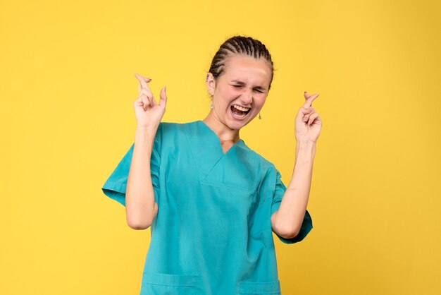 Medico femminile di vista frontale in camicia medica che incrocia le sue dita, emozione del virus dell'ospedale covid-19 dell'infermiera di salute di colore