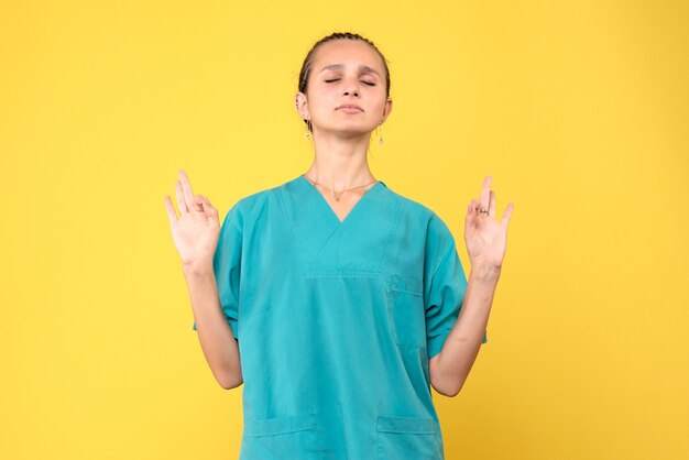 Medico femminile di vista frontale in camicia medica che medita, virus della salute covid-19 dell'infermiera dell'ospedale di colore