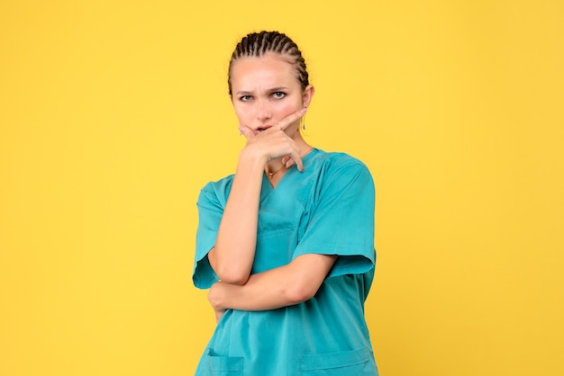 Medico femminile di vista frontale in camicia medica che posa e pensa, virus di salute di colore covid-19 dell'infermiera dell'ospedale