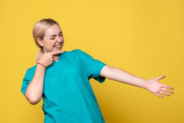 Medico femminile di vista frontale in camicia medica che ride, emozione pandemica covid-19 dell'ospedale medico dell'infermiere