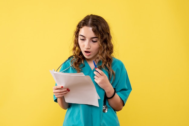 Medico femminile di vista frontale in camicia medica che tiene analisi, virus pandemico di emozioni di salute covid-19 uniforme