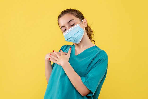 Medico femminile di vista frontale in camicia medica e maschera, pandemia covid di colore di salute uniforme