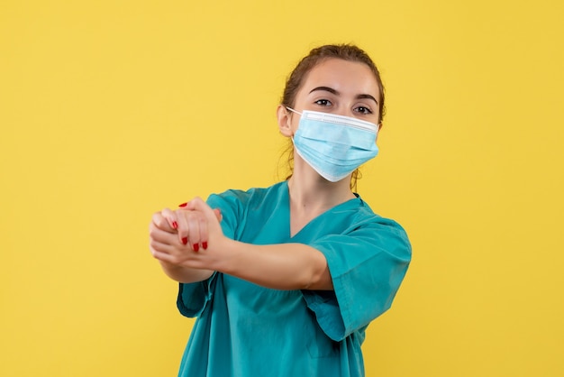 Medico femminile di vista frontale in camicia medica e maschera, salute uniforme covid-19 pandemia di virus