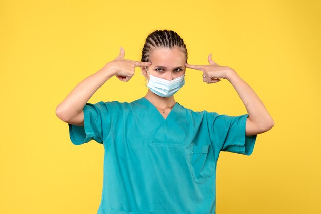 Medico femminile di vista frontale in camicia medica e maschera sterile, medico covid-19 dell'ospedale pandemico del virus dell'infermiere di salute