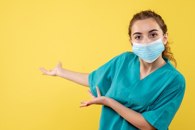 Medico femminile di vista frontale in camicia medica e maschera sterile, uniforme covid del virus di salute di colore