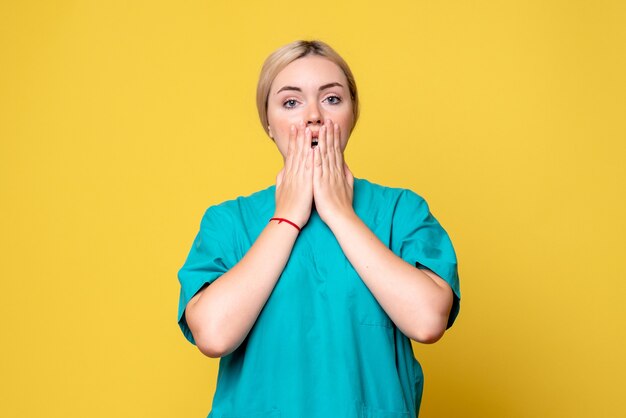 Medico femminile di vista frontale in camicia medica sorpreso, emozione covid-19 del medico dell'infermiera pandemica