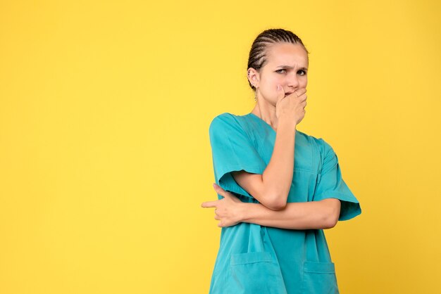 Medico femminile di vista frontale in camicia medica spaventato, ospedale di colore del virus covid-19 dell'infermiera di salute di emozione