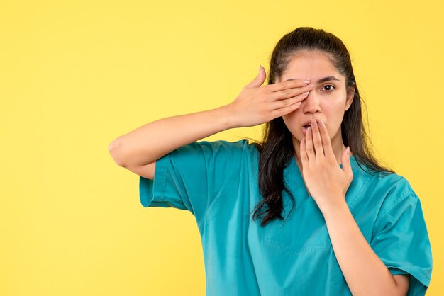 Medico femminile di vista frontale in uniforme che mette le mani