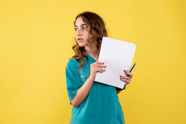 Medico femminile di vista frontale nell'analisi medica della tenuta della camicia, virus pandemico di emozione di salute covid-19 uniforme