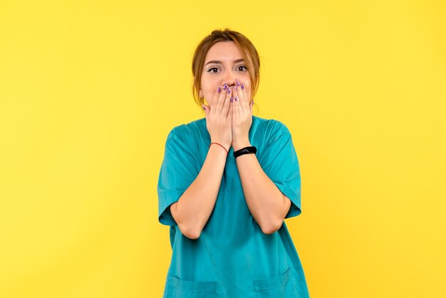 Medico femminile di vista frontale sorpreso sullo spazio giallo