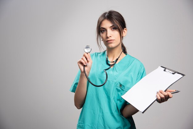 Medico femminile in posa stetoscopio e appunti