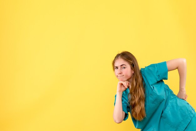 Medico femminile vista frontale che pensa sull'ospedale di emozioni del medico di salute del fondo giallo