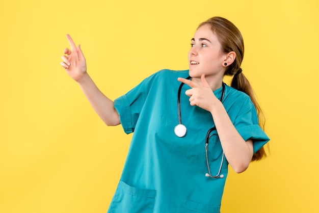 Medico femminile vista frontale su sfondo giallo emozioni ospedale salute medic