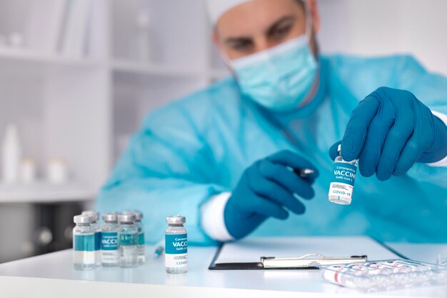 Medico in attrezzatura speciale che si prepara a vaccinare un paziente