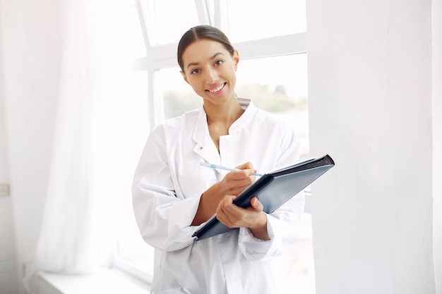 Medico in un'uniforme che sta sul bianco