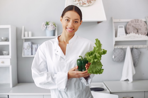 Medico in una cucina con verdure