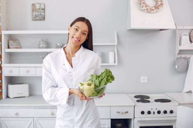 Medico in una cucina con verdure