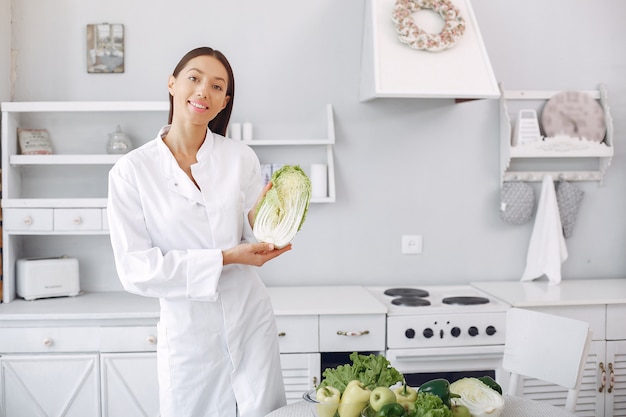 Medico in una cucina con verdure