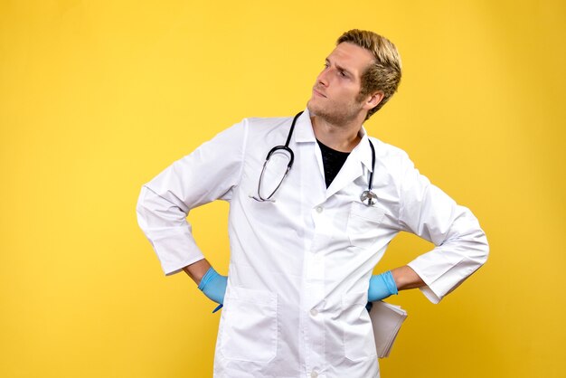 Medico maschio di vista frontale che tiene analisi sul medico di salute dell'ospedale di igiene dello scrittorio giallo