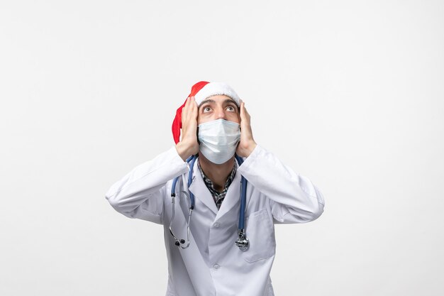 Medico maschio vista frontale con maschera sul virus pandemico covid vacanza pavimento bianco