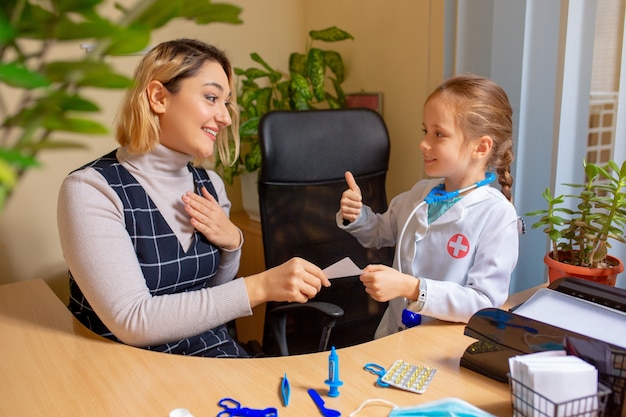 Medico pediatra che esamina un bambino in comodo studio medico. Concetto di assistenza sanitaria, infanzia, medicina, protezione e prevenzione.