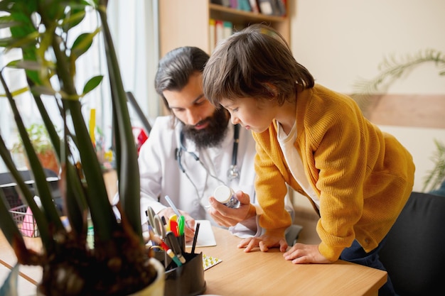 Medico pediatra che esamina un bambino in uno studio medico confortevole